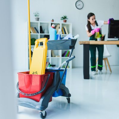 Female janitor cleaning office desk